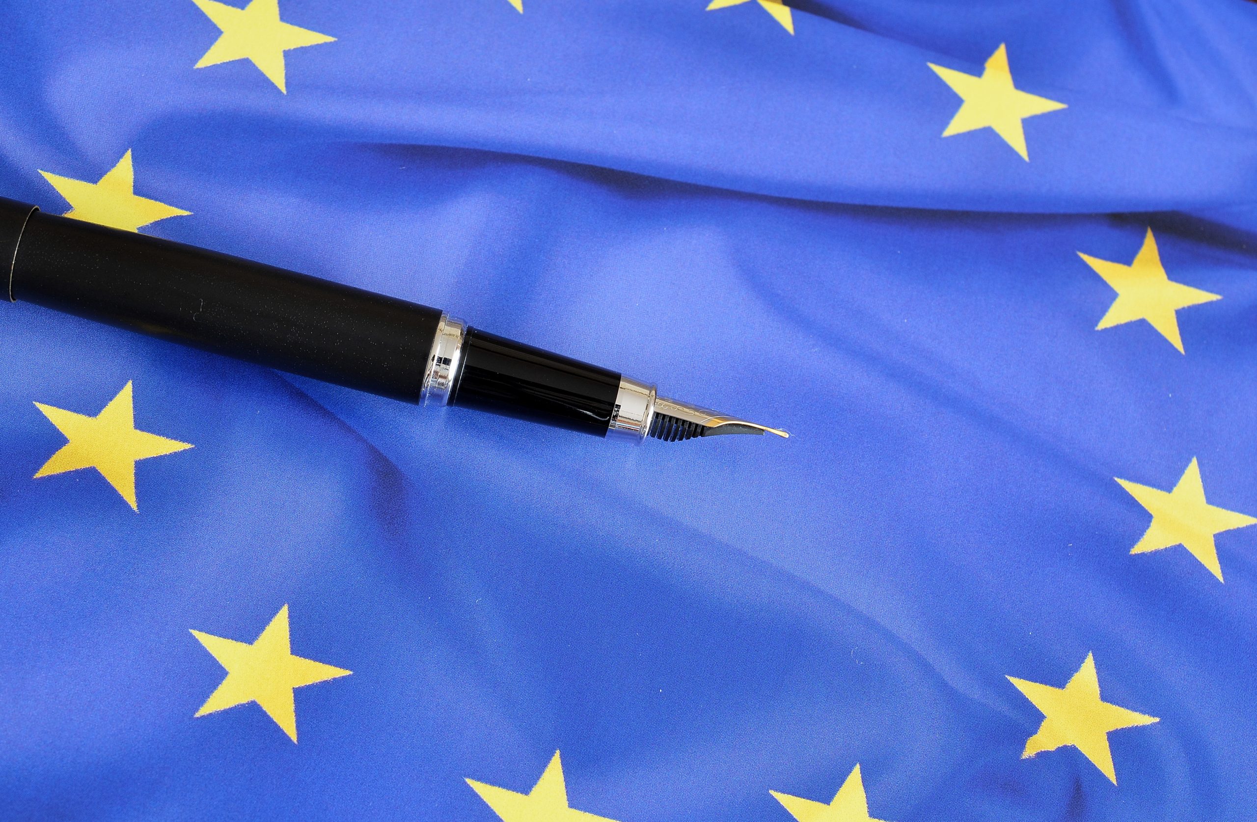 Pióro na tle flagi Unii Europejskiej - ilustracja dekoracyjna